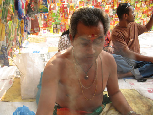 Hindu-Priester mit Tüten umgeben